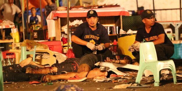 Philippine police investigators check bodies at a blast site at a night market that has left at least several people dead and wounded others in southern Davao city, Philippines late Friday Sept. 2, 2016. The powerful explosion at a night market late Friday in Philippine President Rodrigo Duterte's hometown in the southern Philippines took place amid a security alert due to a major offensive against Abu Sayyaf militants in the region, officials said. (AP Photo/Manman Dejeto)