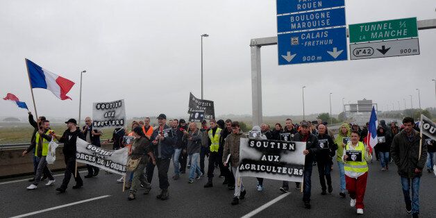 People block the highway leading to Calais and the Channel tunnel in Calais, northern France, Monday, Sept. 5, 2016. Hundreds of truckers in big rigs, farmers in tractors and dockers and merchants on foot blocked a major highway in northern France on Monday to demand the closure of the Calais migrant camp known as the