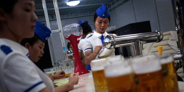A waitress fill up jugs of beer during Taedonggang Beer Festival in Pyongyang, North Korea, Sunday, Aug. 21, 2016. The festival, the first of its kind in the country, was held as a promotional event for the locally brewed beer. (AP Photo/Dita Alangkara)