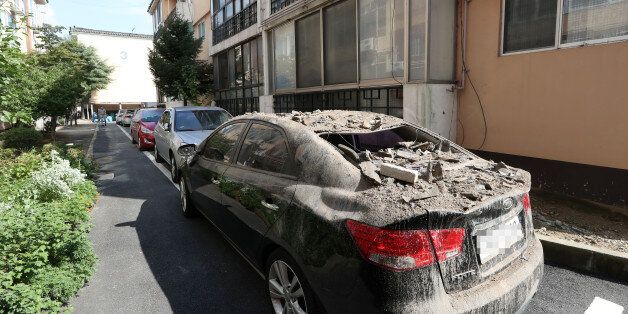 13일 오후 경북 경주시 성건동의 한 아파트에 주차된 차량 위에 전날 지진의 영향으로 떨어진 기와가 쌓여 있다.