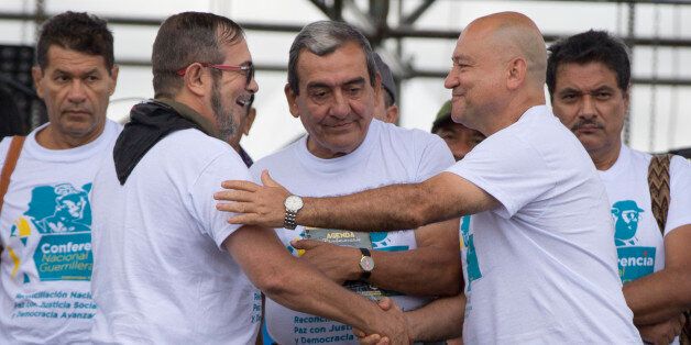 Rodrigo Londono, the top leader of the Revolutionary Armed Forces of Colombia, FARC, also known as Timoleon Jimenez, second from left, is greeted by rebel leaders Carlos Antonio Lozada, and Mauricio Jaramillo, center, after his speech to inaugurate the group's 10th conference in Yari Plains, southern Colombia, Saturday, Sept. 17, 2016. FARC leaders and guerrilla delegates kicked off their last conference as a rebel army as they look to transition into a political movement following the signing o