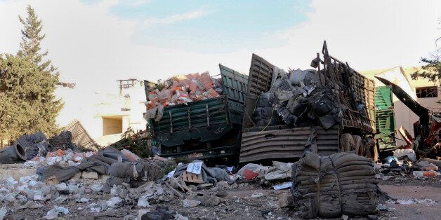 This image provided by the Syrian anti-government group Aleppo 24 news, shows damaged trucks carrying aid, in Aleppo, Syria, Tuesday, Sept. 20, 2016. A U.N. humanitarian aid convoy in Syria was hit by airstrikes Monday as the Syrian military declared that a U.S.-Russian brokered cease-fire had failed, and U.N. officials reported many dead and seriously wounded. (Aleppo 24 news via AP)