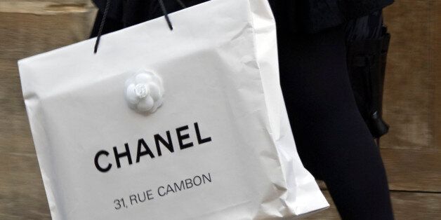 A woman walks with a shopping bag from fashion house Chanel in central Paris October 13, 2008.   REUTERS/Charles Platiau   (FRANCE)