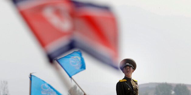 In this Sept. 24, 2016 file photo, a North Korean military soldier stands guard as North Koreans wave flags and cheer during an aerial display, in Wonsan, North Korea. North Korea on Saturday opened an air festival featuring sky diving, demonstrations by its air force and lots of beer to promote a newly renovated and upgraded commercial airport in the coastal city of Wonsan that it hopes will draw for foreign tourists. (AP Photo/Wong Maye-E, File)