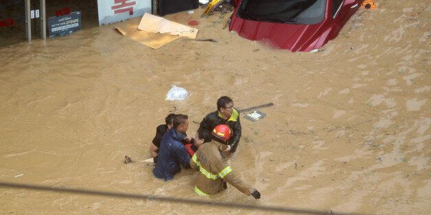 태풍 차바의 영향으로 울산에 300㎜가 넘는 폭우가 쏟아지면서 곳곳이 침수됐다. 목까지 물에 잠기는 중구 우정동에서 소방관들이 고립된 시민을 구조하고 있다.