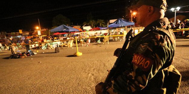 A Philippine soldier keeps watch at a blast site at a night market that has left several people dead and wounded others in southern Davao city, Philippines late Friday Sept. 2, 2016. The powerful explosion in Philippine President Rodrigo Duterte's hometown in the southern Philippines took place amid a security alert due to a major offensive against Abu Sayyaf militants in the region, officials said. (AP Photo/Manman Dejeto)