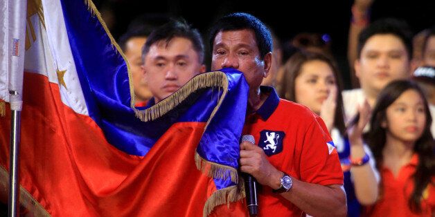 Philippine presidential candidate and Davao city mayor Rodrigo 'Digong' Duterte kisses the Philippine flag during a