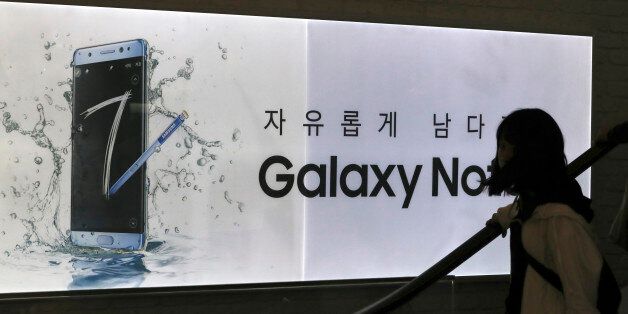 A visitor passes by an advertisement of the Samsung Electronics Galaxy Note 7 smartphone at its shop in Seoul, South Korea, Tuesday, Oct. 11, 2016. Samsung said Tuesday it is halting sales of the star-crossed Galaxy Note 7 smartphone after a spate of fires involving new devices that were supposed to be safe replacements for recalled models. (AP Photo/Lee Jin-man)