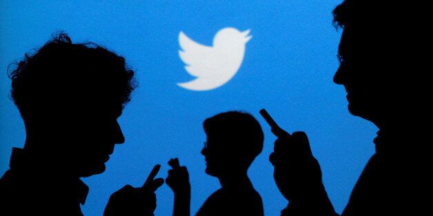 FILE PHOTO --  People holding mobile phones are silhouetted against a backdrop projected with the Twitter logo in this illustration picture taken in  Warsaw September 27, 2013.   REUTERS/Kacper Pempel/Illustration/File Photo