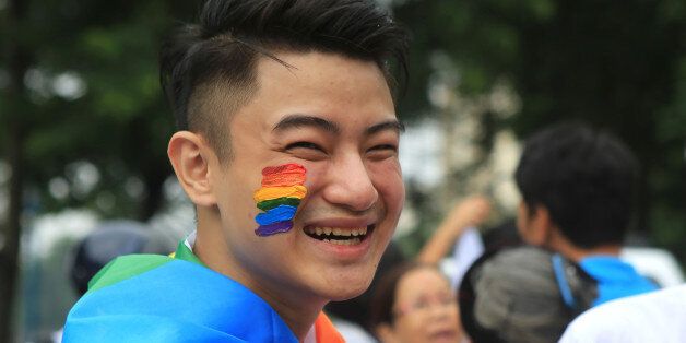 Nguyen Tran Dai Hai smiles during a gay pride parade in Hanoi, Vietnam, Sunday, Aug. 21, 2016. About one thousand people hit the streets of Hanoi to celebrate the annual gay pride parade and rally for human rights. (AP Photo/Hau Dinh)
