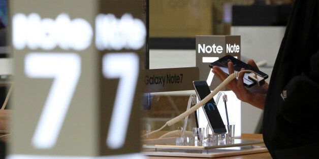 In this Tuesday, Oct. 11, 2016 photo, a visitor tries out a Samsung Electronics Galaxy Note 7 smartphone at its shop in Seoul, South Korea. South Korea's third-quarter economic growth has slipped to its lowest level in more than a year, with Samsung's Galaxy Note 7 recall having an impact. (AP Photo/Lee Jin-man)