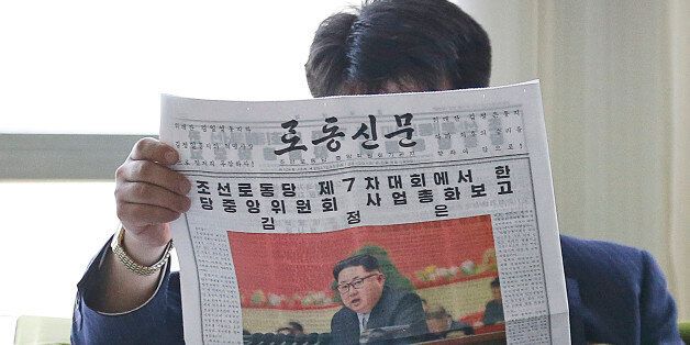 A North Korean man reads a local newspaper with an image of leader Kim Jong Un Sunday, May 8, 2016, in Pyongyang, North Korea. North Korean leader Kim Jong Un said during a critical ruling party congress that his country will not use its nuclear weapons first unless its sovereignty is invaded, state media reported. (AP Photo/Kim Kwang Hyon)