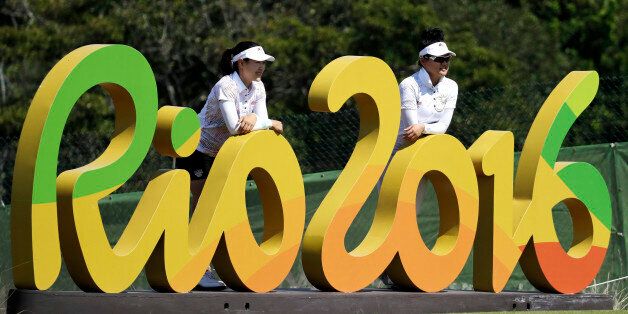FILE  - In this Aug.16, 2016 file photo, Kelly Tan, left, and Michelle Koh both of Malaysia, pose for a photo with the Rio 2016 logo on the 16th hole during a practice round for the women's golf event at the 2016 Summer Olympics in Rio de Janeiro, Brazil. The Rio Olympics could leave behind at least one unexpected legacy _ a new home for the consular office of the United States. The headquarters of the Rio de Janeiro Olympic organizing committee in central Rio will be abandoned in the next few w