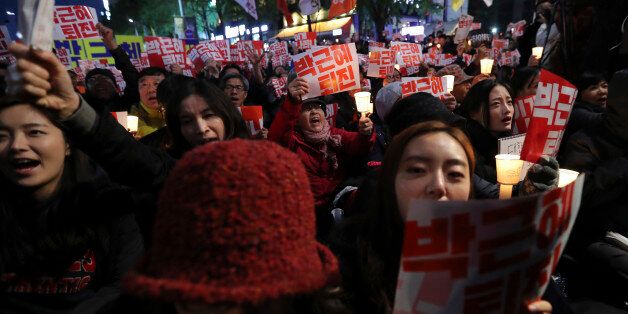 South Koreans shout slogans during an anti-president rally in downtown Seoul, South Korea, Saturday, Oct. 29, 2016. Thousands of South Koreans took to the streets of the capital on Saturday calling for increasingly unpopular President Park Geun-hye to step down over allegations that she let an old friend, the daughter of a religious cult leader, interfere in important state affairs. (AP Photo/Lee Jin-man)