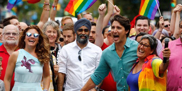 Canada's Prime Minister Justin Trudeau reacts as he and his wife Sophie GrÃ©goire Trudeau (L) walk in the Vancouver Pride Parade in Vancouver, British Columbia, July 31, 2016. REUTERS/Ben Nelms