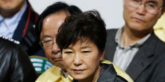 South Korean President Park Geun-hye (C) listens to a family member of a missing passenger who was on South Korean ferry