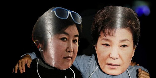 Protesters wearing cut-out of South Korean President Park Geun-hye (R) and Choi Soon-sil attend a protest denouncing President Park Geun-hye over a recent influence-peddling scandal in central Seoul, South Korea, October 27, 2016.  REUTERS/Kim Hong-Ji