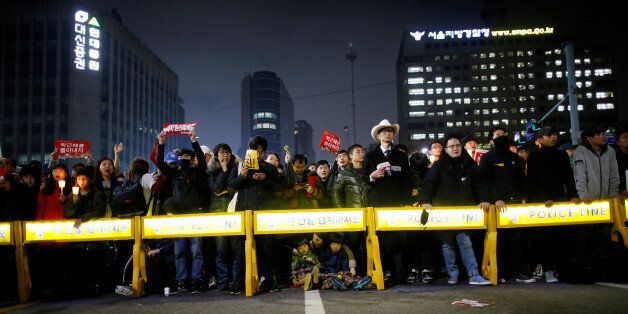 People stand behind barricades on a road leading to the Presidential Blue House during a protest calling South Korean President Park Geun-hye to step down in Seoul, South Korea, November 19, 2016. REUTERS/Kim Hong-Ji