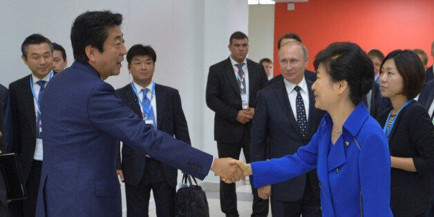 Japanese Prime Minister Shinzo Abe (L) shakes hands with South Korean President Park Geun-hye as Russian President Vladimir Putin stands in the background during the Eastern Economic Forum in Vladivostok, Russia, September 3, 2016. Sputnik/Kremlin/Alexei Druzhinin/via REUTERS  ATTENTION EDITORS - THIS IMAGE WAS PROVIDED BY A THIRD PARTY. EDITORIAL USE ONLY.