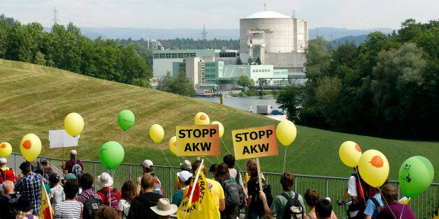 Protesters carry posters demanding a stop to nuclear power plants as they march in front of the power plant Beznau in the Swiss town of Doettingen, some 45 km (28 miles) northwest of Zurich May 22, 2011. Some 14,000 people took part in a demonstration against the use of nuclear energy.  REUTERS/Arnd Wiegmann (SWITZERLAND - Tags: ENERGY ENVIRONMENT CIVIL UNREST)