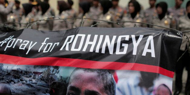 A banner is seen during a protest against what demonstrators say is the crackdown on ethnic Rohingya Muslims in Myanmar, as police stand guard in front of the Myanmar embassy in Jakarta, Indonesia November 25, 2016. REUTERS/Beawiharta