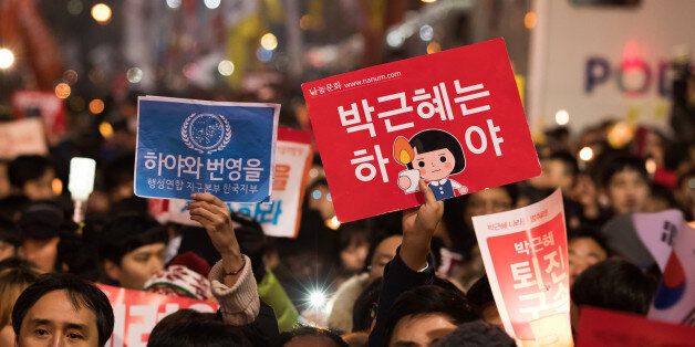 Protesters hold placards during a rally in Seoul, South Korea, on Saturday, Nov. 26, 2016. Hundreds of thousands of South Korean protesters marched to President Park Geun-hye's office, beating drums and chanting slogans, even as lawmakers considered impeaching her over an influence-peddling scandal. Photographer: SeongJoon Cho/Bloomberg via Getty Images
