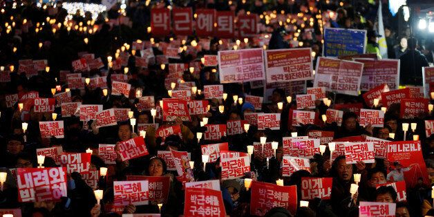 People chant slogans during a protest calling for South Korean President Park Geun-hye to step down in central Seoul, South Korea, November 29, 2016. The sign reads