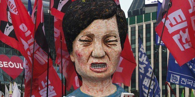 Protesters carry an effigy of South Korea's President Park Geun-Hye during an anti-government rally demanding the resignation of the president in central Seoul on November 30, 2016.An impeachment vote against South Korea's scandal-hit president will be postponed by at least a week, lawmakers said on November 30, after Park Geun-Hye announced she was willing to stand down early. / AFP / JUNG Yeon-Je        (Photo credit should read JUNG YEON-JE/AFP/Getty Images)