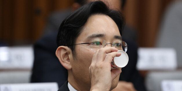 Jay Y. Lee, co-vice chairman of Samsung Electronics Co., takes a drink during a parliamentary hearing at the National Assembly in Seoul, South Korea, on Tuesday, Dec. 6, 2016. Lee, the de-facto head of Samsung, became the focus of the hearing of South Korea's top tycoons in connection with a widening influence-peddling scandal that may cost the country's president her job. Photographer: SeongJoon Cho/Bloomberg via Getty Images