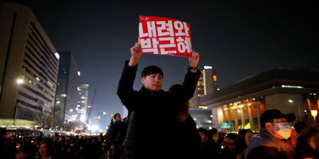 A man holds up a sign that reads