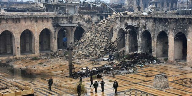 TOPSHOT - A general view shows Syrian pro-government forces walking in the ancient Umayyad mosque in the old city of Aleppo on December 13, 2016, after they captured the area.After weeks of heavy fighting, regime forces were poised to take full control of Aleppo, dealing the biggest blow to Syria's rebellion in more than five years of civil war. / AFP / George OURFALIAN        (Photo credit should read GEORGE OURFALIAN/AFP/Getty Images)