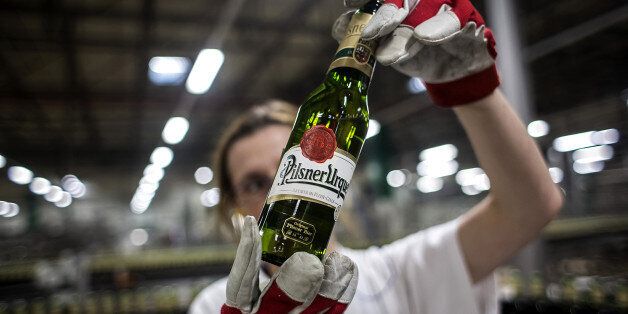 A worker holds up a bottle of beer against the light during a quality control inspection on the production line at the Pilsner Urquell brewery, operated by SABMiller Plc, in Plzen, Czech Republic, on Monday, Dec. 7, 2015. Carrying the Czech Beer label requires the use of specific types of Czech-grown barley and hops that give the domestic brew its characteristic bitterness, aroma and drinkability, said Vladimir Balach, the head of the Czech Beer and Malt Association in a 2014 interview. Photogra