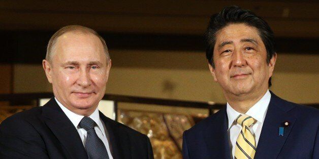 JAPAN, NAGATO - DECEMBER  15: (RUSSIA OUT) Russian President Vladimir Putin (L) shakes hands with Japanese Prime Minister Shinzo Abe (R) during the official reception ceremony on December 15, 2016  in Nagato, Japan. The Russian president is on a two-days visit to Japan. (Photo by Mikhail Svetlov/Getty Images)