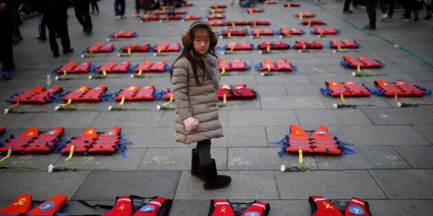 A girl stands between life vests symbolising the 304 victims of sunken ferry Sewol during a protest demanding South Korean President Park Geun-hye's resignation in Seoul, South Korea December 17, 2016.  REUTERS/Kim Hong-Ji