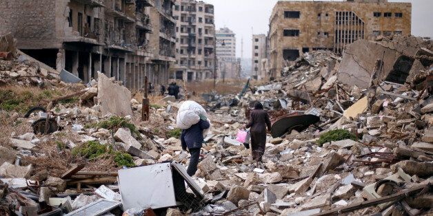 People walk amid the rubble as they carry belongings that they collected from their houses in the government controlled area of Aleppo, Syria December 17, 2016. REUTERS/Omar Sanadiki
