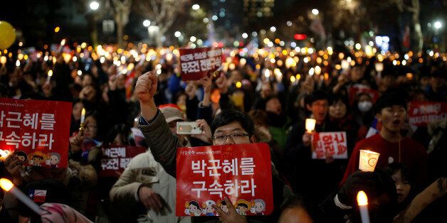 People march toward the constitutional court during a protest demanding South Korean President Park Geun-hye's resignation in Seoul, South Korea December 17, 2016. The sign reads