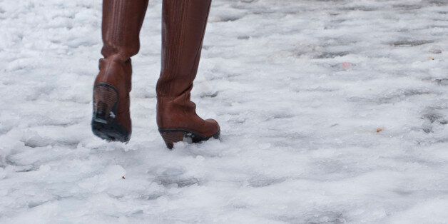 Woman with brown leather boots walks on icy street in Rome