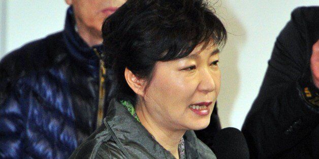South Korea's President Park Geun-Hye (C) speaks during a visit to relatives of missing passengers on board a capsized ferry as they wait for updates about their loved ones at a gym in Jindo on April 17, 2014. Rescuers worked frantically on April 17 to find 300 people -- mostly schoolchildren -- missing after a South Korean ferry capsized, with prospects of pulling survivors from the submerged vessel dimming as emotions boiled over among anguished relatives.       AFP PHOTO / JUNG YEON-JE