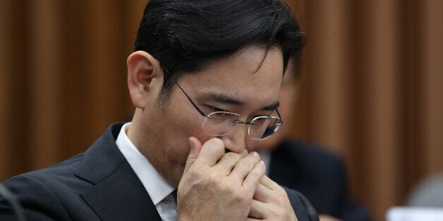 Jay Y. Lee, co-vice chairman of Samsung Electronics Co., applies lip-balm during a parliamentary hearing at the National Assembly in Seoul, South Korea, on Tuesday, Dec. 6, 2016. Lee, the de-facto head of Samsung, became the focus of the hearing of South Korea's top tycoons in connection with a widening influence-peddling scandal that may cost the country's president her job. Photographer: SeongJoon Cho/Bloomberg via Getty Images
