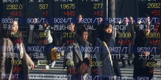Pedestrians are reflected in an electric quotation board flashing stock prices on the Tokyo Stock Exchange in Tokyo on January 4, 2017.Tokyo shares surged in the morning on January 4 on the first trading day of 2017, following gains on Wall Street driven by optimism over the US economy. / AFP / KAZUHIRO NOGI        (Photo credit should read KAZUHIRO NOGI/AFP/Getty Images)