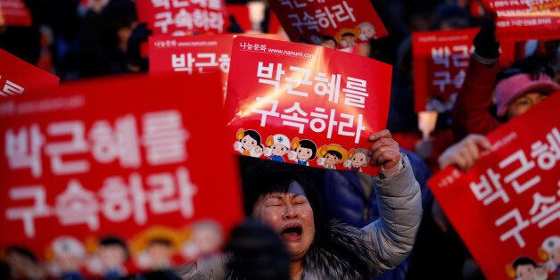 People attend a protest demanding South Korean President Park Geun-hye's resignation in Seoul, South Korea December 17, 2016. The signs read