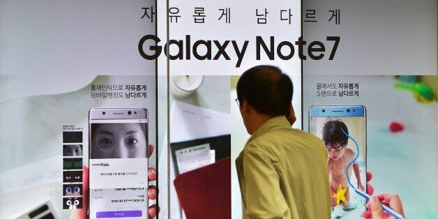 A man speaks over his phone in front of a signboard of the Samsung Galaxy Note7 at a Samsung showroom in Seoul on September 2, 2016.Samsung will suspend sales of its latest high-end smartphone Galaxy Note 7 after reports of exploding batteries, its mobile chief said on September 2.  / AFP / JUNG YEON-JE        (Photo credit should read JUNG YEON-JE/AFP/Getty Images)