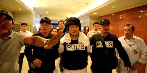 Police officer Ricky Sta. Isabel (C), one of the suspects in the kidnapping and murder of South Korean businessman Jee Ick Joo, is escorted by fellow policemen as they leave the National Bureau of Investigation (NBI) building in Manila on January 20, 2017. A South Korean businessman kidnapped by Philippine policemen under the guise of a raid on illegal drugs was murdered at the national police headquarters in Manila, authorities said Thursday. / AFP / NOEL CELIS        (Photo credit should read