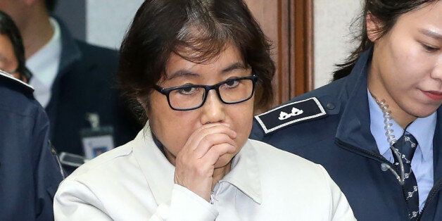 Choi Soon-Sil (C), who has been dubbed Korea's 'female Rasputin' for the influence she wielded over the now-impeached president Park Geun-Hye, arrives at a courtroom for her trial at the Seoul Central District Court in Seoul on December 19, 2016.The woman at the centre of a corruption scandal that triggered the biggest political crisis for a generation in South Korea appeared in court on December 19 for a preliminary hearing in her trial on fraud charges. / AFP / KOREA POOL / KOREA POOL / South