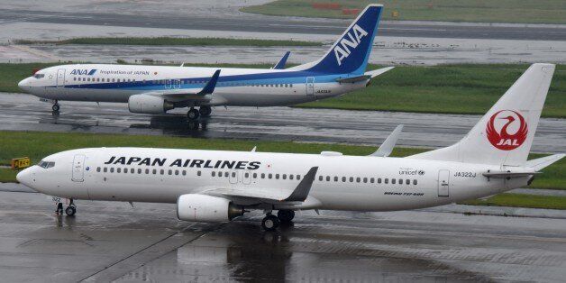 All Nippon Airways (ANA/top) and Japan Airlines (JAL/bottom) aircraft are seen at Haneda Airport in Tokyo on April 28, 2016. The Japanese airline will announce its financial results for fiscal year 2015 ended March 2016. / AFP / TORU YAMANAKA        (Photo credit should read TORU YAMANAKA/AFP/Getty Images)