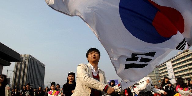 SEOUL, SOUTH KOREA - FEBRUARY 22:  A South Korean student waves national flags during an anti-Japan rally on February 22, 2014 in Seoul, South Korea. South Korea and Japan are making claim to a set of islands controlled by South Korea, Dokdo or Takeshima, located in the East Sea. The rally was taking place after the Japanese government declared today to be Takeshima Day, further fueling a long-standing territorial row between the two countries.  (Photo by Chung Sung-Jun/Getty Images)