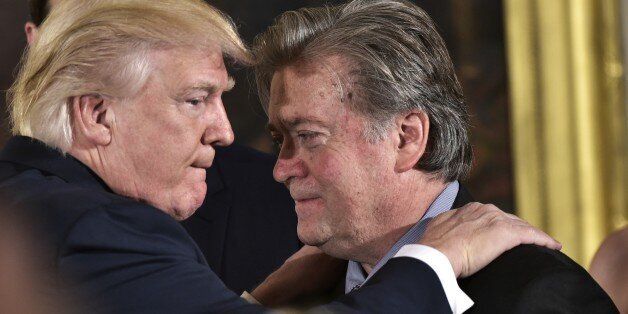 US President Donald Trump (L) congratulates Senior Counselor to the President Stephen Bannon during the swearing-in of senior staff in the East Room of the White House on January 22, 2017 in Washington, DC. / AFP / MANDEL NGAN        (Photo credit should read MANDEL NGAN/AFP/Getty Images)