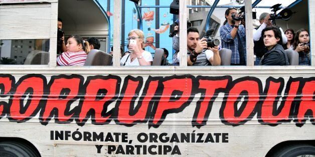 Journalists and tourists are pictured on board of  the 'Corruptour', a bus that offers a sightseeing tour through different points, institutions and companies in Mexico City, related to alleged great scandals of corruption in recent Mexican history, on February 5, 2017. The 'Corruptour' is a new and free touristic attraction launched and supported by NGO's and activists proposing a route arround 10 sites related to alleged corruption scandals such as the Mexican Senate, the offices of the Mexica