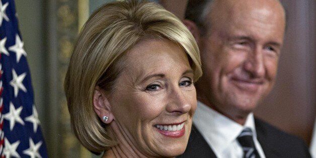 Betsy DeVos, U.S. Secretary of Education, left, stands with her husband Dick DeVos Jr. before being sworn-in by U.S. Vice President Mike Pence, not pictured, inside the Vice President's Ceremonial Office in Washington, D.C., U.S., on Tuesday, Feb. 7, 2017. DeVos squeaked through a history-making Senate confirmation vote to become U.S. education secretary, as Vice President Mike Pence broke a 50-50 tie and Republicans staved off last-minute defections that would have killed her nomination. Photog