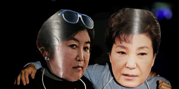 Protesters wearing cut-out of South Korean President Park Geun-hye (R) and Choi Soon-sil attend a protest denouncing President Park Geun-hye over a recent influence-peddling scandal in central Seoul, South Korea, October 27, 2016.  REUTERS/Kim Hong-Ji